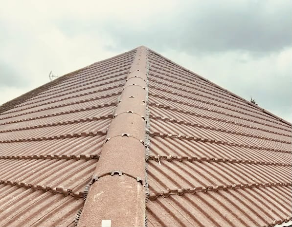Professional roofer working on a UK house